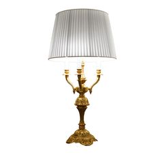 a gold lamp with a white shade on it's base and a silver lampshade