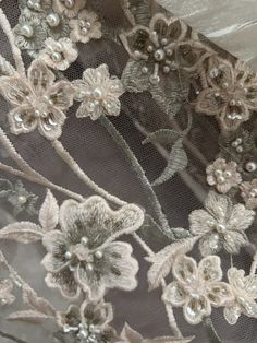 an embroidered fabric with flowers and pearls on it