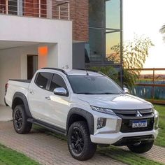 a white pick up truck parked in front of a house