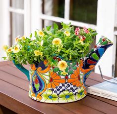 a potted plant sitting on top of a wooden table next to a book and window