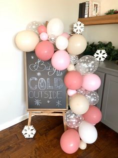 a chalkboard with balloons and snowflakes on it in front of a christmas sign