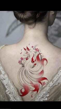 the back of a woman's neck is decorated with red and white flowers on it