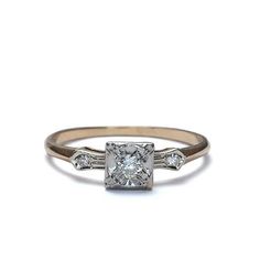 an engagement ring with three diamonds on the sides and a center stone in the middle