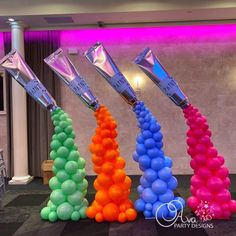 there are many different colored balloons in the shape of cones and vases on the floor