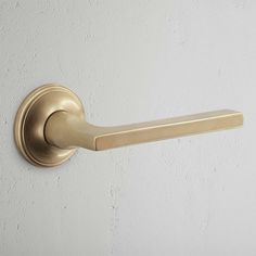 an image of a gold door handle on a white wall