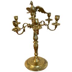 an antique brass candelabra with five candles and two doves on it