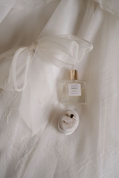 a bottle of perfume sitting on top of a white sheet