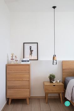 a bedroom with white walls and wooden furniture