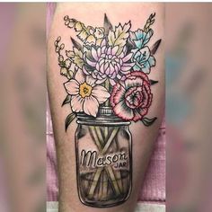 a jar filled with flowers on top of a woman's leg and the words mason jar written in it