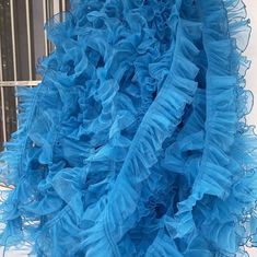 a blue dress hanging from the side of a building with a window in the background