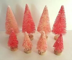 small pink christmas trees are lined up against a white background