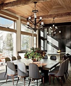 a dining room table with chairs and a chandelier hanging from it's ceiling