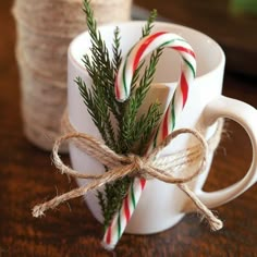 two mugs with candy canes tied to them