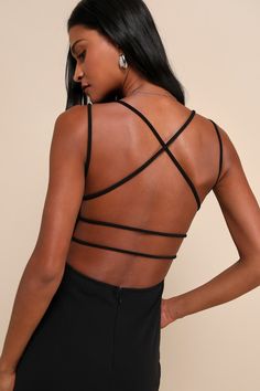 the back of a woman's body wearing a black dress with cross - over straps