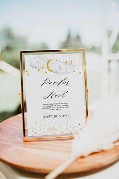 a close up of a table with a sign on it and flowers in the background