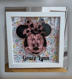 a mickey mouse shadow in a frame with the word grace lynn on it's face