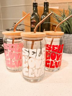 three jars with straws in them sitting on a counter