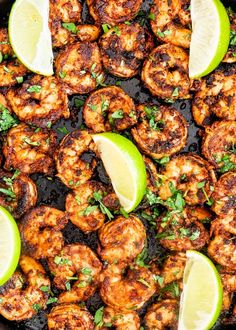 a skillet filled with shrimp and limes