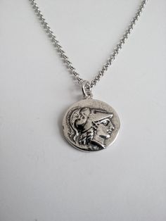 Varouxi Pendant Goddess Athena Silver 925 a very nice pendant in silver 925 a souvenir from ancient Greece accompanied by a silver chain 925 length 45cm Diameter coin:18mm Weight coin:5,0gr total weight:9,2gr Metal:silver 925 MACEDONIAN KINGS. Alexander the Great. 323-317 B.C. E. Head of Goddess Athena O.The Goddess Nike with laurel wreath All creations are specially designed, hand cast of solid silver, and individually polished Black oxidised background to enhance ( coin ) symbols Made entirely Goddess Nike, Goddess Athena, Athena Goddess, Alexander The Great, Laurel Wreath, Hand Cast, The Goddess, Ancient Greece, Beautiful Gift Boxes