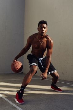 a shirtless man holding a basketball in his right hand