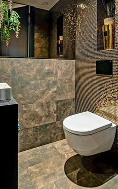 a bathroom with a toilet, sink and tiled walls in it's center area