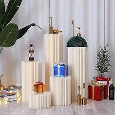 three white vases are stacked on top of each other with presents in front of them