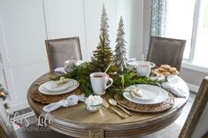 a table set for christmas with plates and cups