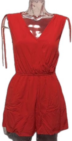 Chic Red Jumpsuits And Rompers For Summer, Chic Red Jumpsuits And Rompers For Vacation, Casual Red V-neck Jumpsuit, Casual Red V-neck Jumpsuits And Rompers, Casual Red Cotton Jumpsuits And Rompers, Red Jumpsuits And Rompers For Summer Day Out, Red Beach Jumpsuit With Pockets, Red Jumpsuits And Rompers With Pockets For Beach, Red Beach Jumpsuits And Rompers With Pockets