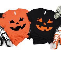 three halloween t - shirts with pumpkin faces on them, one is orange and the other is black