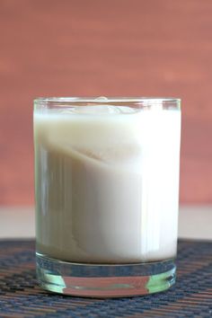 a glass filled with milk sitting on top of a table