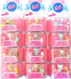 the littlest pet shop toys are in plastic containers with pink caps and bows on them