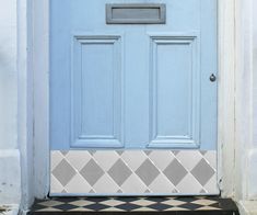 a blue front door with a black and white checkerboard pattern on the floor