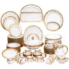 an assortment of white and gold china