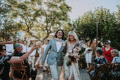 a bride and groom walk down the aisle as confetti is thrown around them