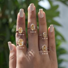 a woman's hand with three different rings on her fingers and the other two are showing