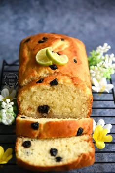 a loaf of lemon blueberry bread on a cooling rack with flowers and daisies