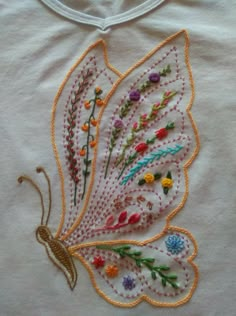 an embroidered butterfly on a white t - shirt