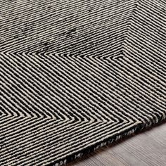 a black and white rug on top of a wooden floor