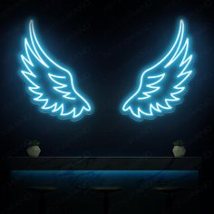 two white angel wings on a black wall with blue lights in the dark, above a bar