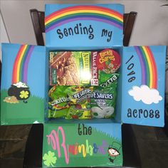 a box filled with candy sitting on top of a wooden chair in front of a rainbow sign