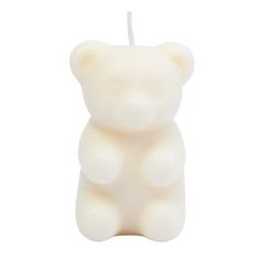 a small white candle with a bear on it's front and back end, in the shape of a teddy bear