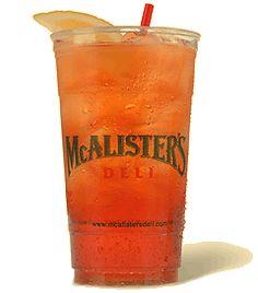 an orange drink with a slice of lemon on the rim and a red straw sticking out of it