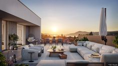 an outdoor living area with couches, tables and chairs on the deck at sunset