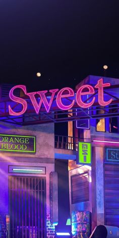 a neon sign that says sweet on the side of a building