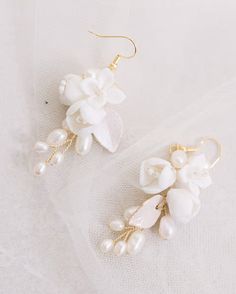 Gold and white ceramic floral bridal drop earrings. An elegant pair of gold wedding earrings. Ceramic flowers, dainty pearls and hand-painted leaves Your earrings come in a beautiful jewellery pouch for safe keeping. Delicate White Pearl Drop Earrings, Pearl Drop Flower Bridal Earrings As Gift, Delicate White Pearl Earrings For Wedding, Elegant White Bridal Earrings With Flower Decoration, Handmade Flower Pearl Earrings For Wedding, Elegant White Flower Earrings With Pearl Drop, Elegant White Flower Earrings Gift, White Pearl Earrings For Wedding, Elegant White Drop Earrings Bridal Accessories