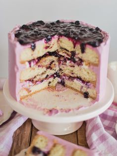 a cake that has been cut into pieces and is sitting on a table with pink napkins