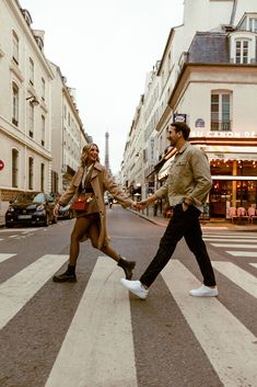 a man and woman crossing the street holding hands