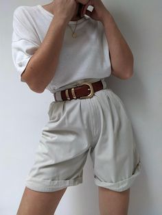 Classic pleated shorts in a khaki cotton. Shorts have a high-rise fit with v-cut at the front of the waist. Includes belt loops, pockets and a cuffed design to the leg. Tag reads Ashworth There are a few small discolored spots at the front waistline - does not affect the overall look or wear. Chic Cotton Bermuda Shorts With Belt Loops, Casual High Waist Shorts With Belt Detail, Casual High-waist Shorts With Belt Detail, Chic Belted Shorts For Summer, Chic Summer Shorts With Belt Detail, Spring Shorts With Belt Detail, Chic Belted Cotton Shorts, Belt Detail Shorts For Summer, Chic High-waisted Shorts With Belt