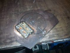 an old clock sitting on top of a piece of metal in the process of being repaired