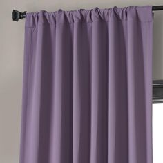 a purple curtain hanging on the side of a window